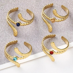 Close-up of golden adjustable snake rings with colorful gemstones and hammered texture
