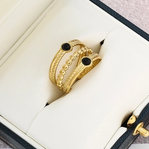 Macro detail of triple-layered gold ring with black stones in a leather jewelry box