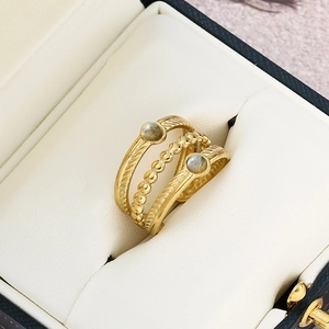 Detail view of gold layered ring with twisted bands and blue natural stone in jewelry box