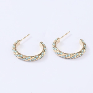 Gold twist rope hoop earrings with blue enamel stones in a minimalist C-shaped design