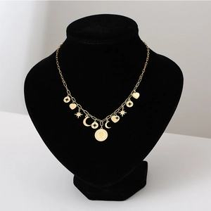 Detail einer goldenen mehrlagigen Kette mit Vintage-Münz-, Stern-, Herz- und Mondanhängern