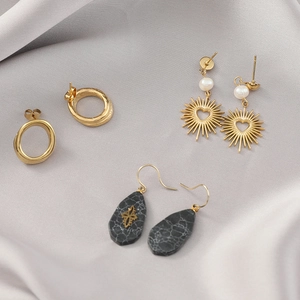 Detailed set of gold oval hoops, pearl heart sunburst earrings and marble drop pendants