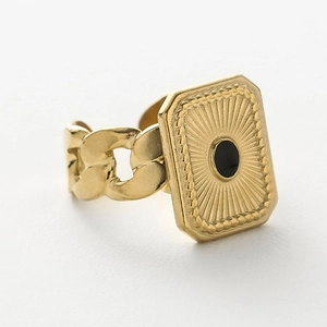 Detailansicht eines goldenen Siegelrings mit Sonnenstrahlmuster und schwarzem Stein