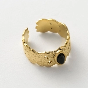 Makroaufnahme von Goldring mit Blattmuster, schwarzem Tropfenstein und Vintage-Gravur