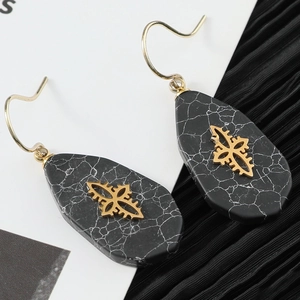 Hollow heart earrings with black marble pattern and gold star drop design in a luxury style