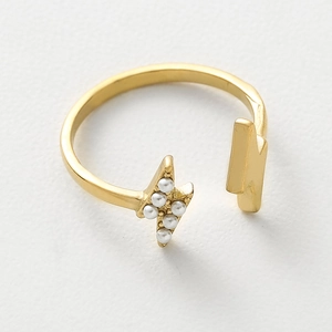 Detail view of a gold lightning ring with small pearls and adjustable open band design