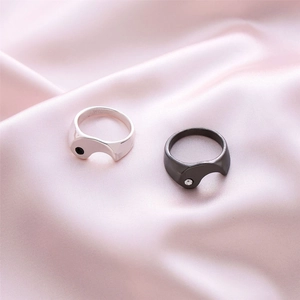 Anelli Tai Chi in acciaio lucido argento e nero su elegante seta rosa morbida