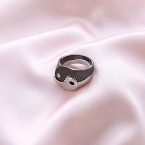 Dettaglio degli anelli Tai Chi intrecciati con zircone bianco su sfondo di seta rosa