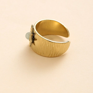 Vintage wide gold steel ring with flower design and green gemstone in 45-degree view