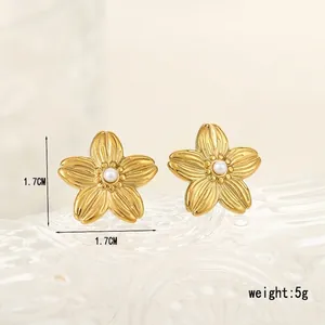 Vue macro de boucles d'oreilles fleurs dorées avec texture radiale et perle blanche centrale