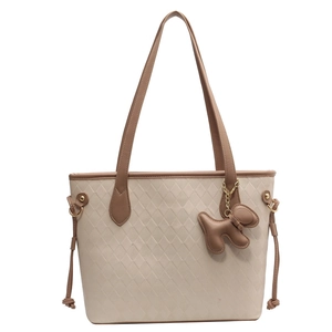 Detail of soft PU tote bag featuring quilted texture, contrast trim and dog charm