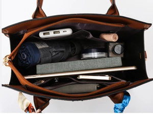 Vista interna del bolso de cuero marrón con gran capacidad y compartimentos útiles