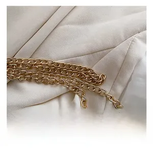 Close-up of premium gold-plated chain strap on high-quality fabric for a saddle bag