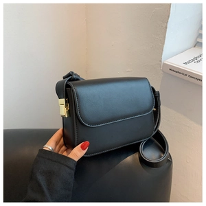 Minimalist black rectangle shoulder bag with gold square lock and matte leather texture