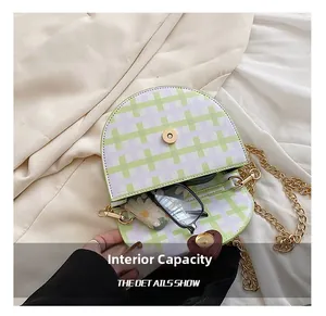 Internal capacity of green and purple plaid saddle bag holding glasses and pouch