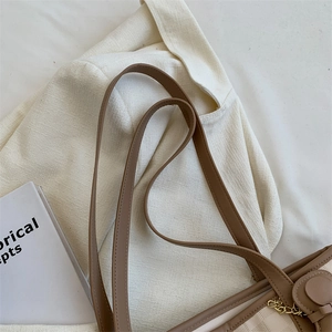 Minimalist beige and brown patchwork tote bag with gold chain detail on single shoulder strap