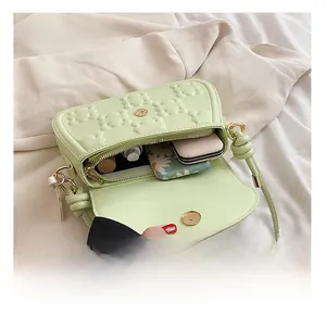 Interior view of light green crossbody bag showing space for phone and makeup items