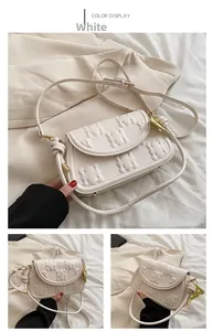Detail showing white textured leather bag with gold hardware and embossed patterns