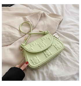 Detail of light green PU leather handbag featuring unique biscuit embossed texture pattern