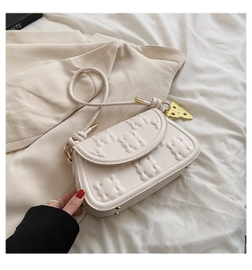 Detail of cream white biscuit texture handbag with cute cheese pendant and thin strap