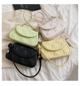 Close-up of quilted biscuit bags in mint, beige, black, and yellow with bear textures