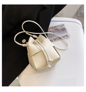 Detail view of woven leather bucket bag with drawstring closure and soft texture