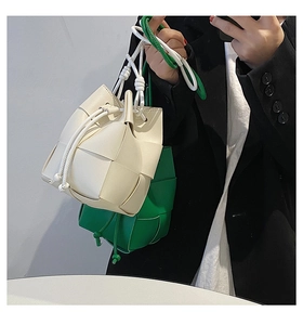 Detail of hand-woven leather bucket bags with drawstring closure and knotted straps
