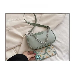 Gros plan du sac carré en similicuir vert clair avec chaîne décorative à fleurs argentées