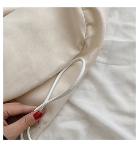 Close-up of cream canvas texture and white leather handle with neat edge stitching