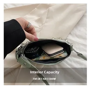 Détail de la capacité interne du sac à bandoulière en cuir vert menthe et accessoires