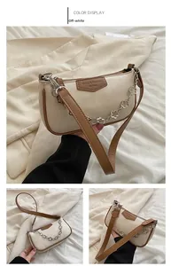 Détail du sac baguette blanc crème avec liseré marron et chaîne à fleurs décorative