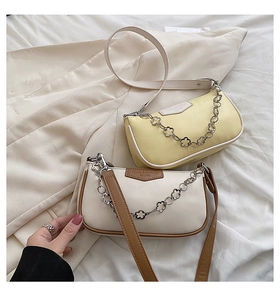 Détail de sacs baguette tendance en crème et jaune avec chaînes en métal à fleurs