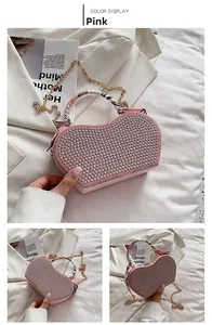 Detail view of pink heart-shaped bag with silver rhinestones and silk ribbon handle