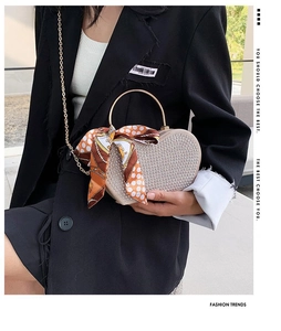 Detail of heart-shaped rhinestone evening bag with silk scarf and gold chain strap