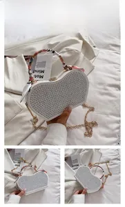 Detail of white heart-shaped bag with silver rivets and floral scarf handle