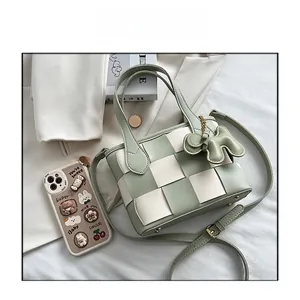 Détail du sac seau tressé vert avec breloque éléphant et bandoulière réglable