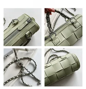 Detail view of light green cylinder woven bag featuring chunky chain and metal buckle