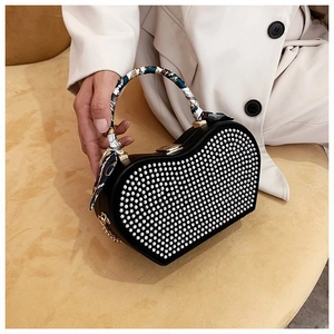 Elegant heart-shaped evening bag with white rhinestones and silk scarf handle detail