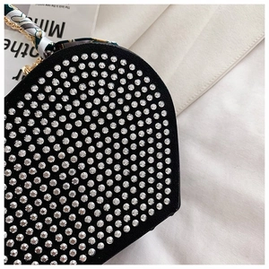 Detail of black heart-shaped handbag with silver rhinestones and silk scarf chain strap