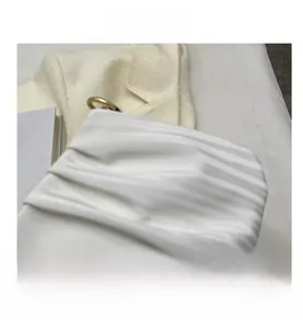 Gros plan détaillé sur le tissu plissé blanc du sac nuage avec anneau en métal doré chic