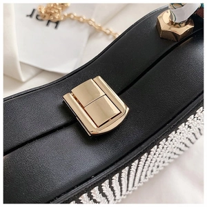 Detail of black leather handbag featuring V-shape rhinestone pattern and gold buckle