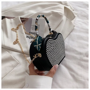 Detail of heart-shaped handbag with silver rivets and floral silk scarf handle wrap