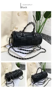 Detail of black woven cylinder handbag featuring chunky silver chain and long strap