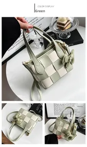 Détail du sac seau tressé à damier vert et crème avec breloque ours et chaîne dorée