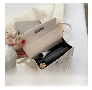 Interior view of off-white crossbody bag showing capacity for phone, wallet and cosmetics
