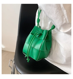 Detail of green hand-woven leather bucket bag with signature drawstring knots