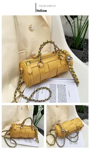 Detail of yellow woven barrel bag featuring chunky chain strap and premium leather texture