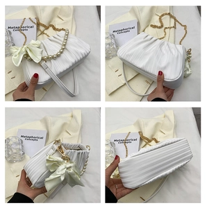 Détails du sac nuage blanc plissé montrant la bandoulière perle et la chaîne dorée