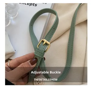 Close-up of mint green leather strap with adjustable golden buckle and fine stitching