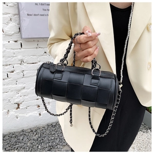Detail of black woven cylinder bag with thick chain handle and pearl shoulder strap
